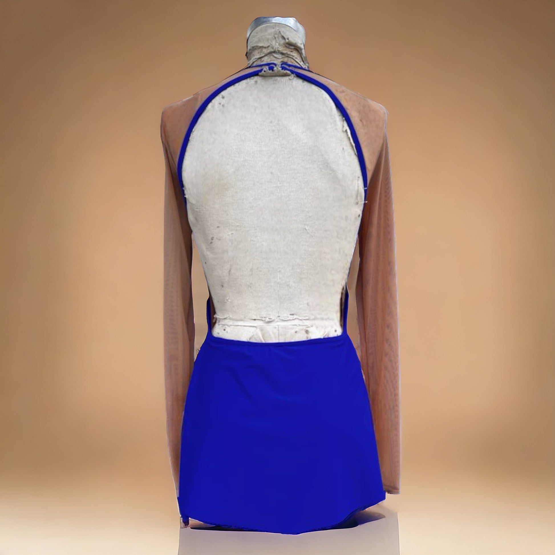Our Sahara Dress is a true stunner! The sides are only constructed in mesh to give the side of the body the longest line possible. The front panel dress and back skirt leaves roughly 2-3 inches of the side open so that as the dancer moves, this illusion provides the most length possible. A boat neckline, an gorgeous open back, and cuffs at the end of the sleeves. The Sahara Dress is always highly requested for group dances, and now, we have a couple available to a lucky two! 